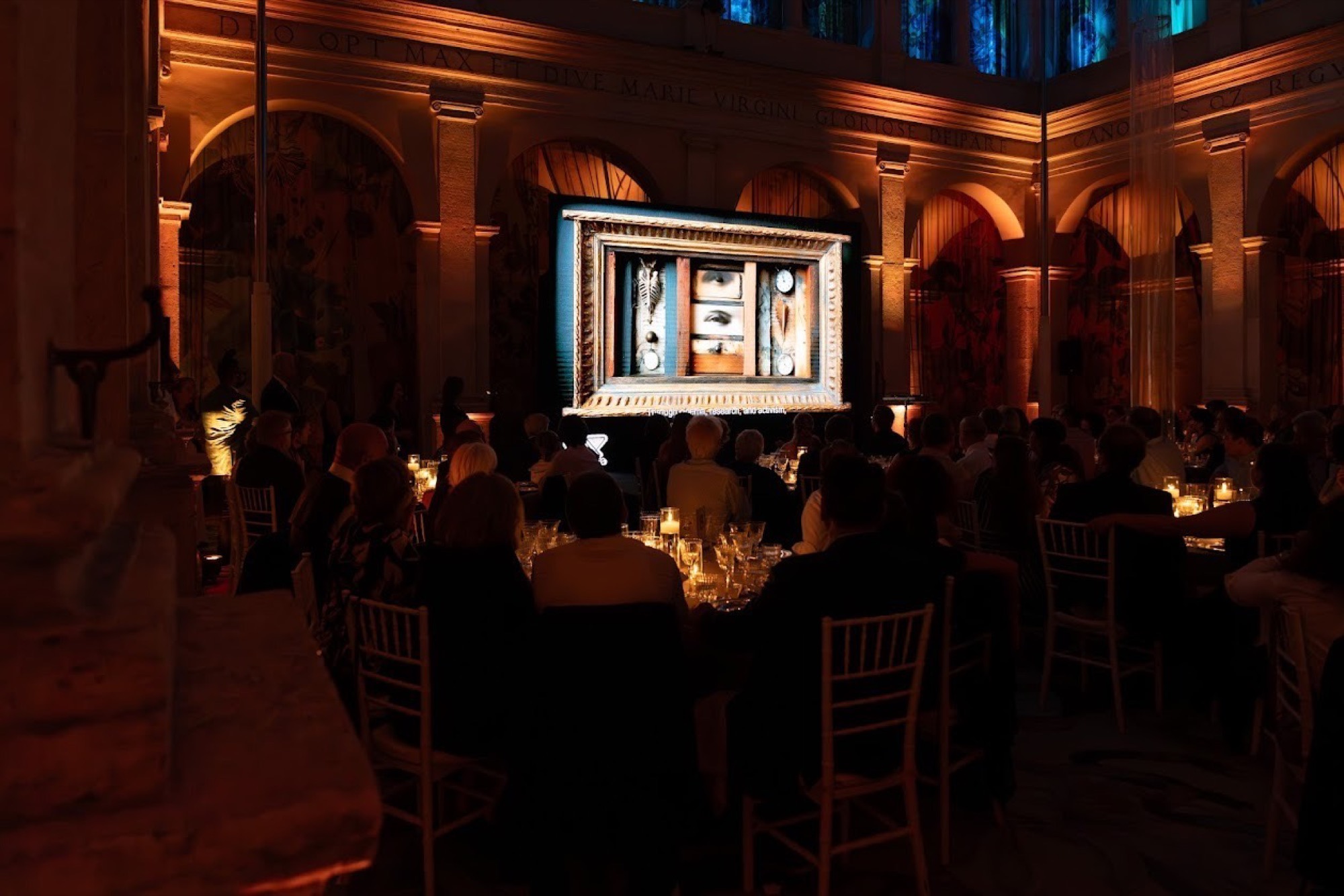 The 2025 prize ceremony: an audience in a darkened hall watching the film for Fred Kuwornu on a large screen