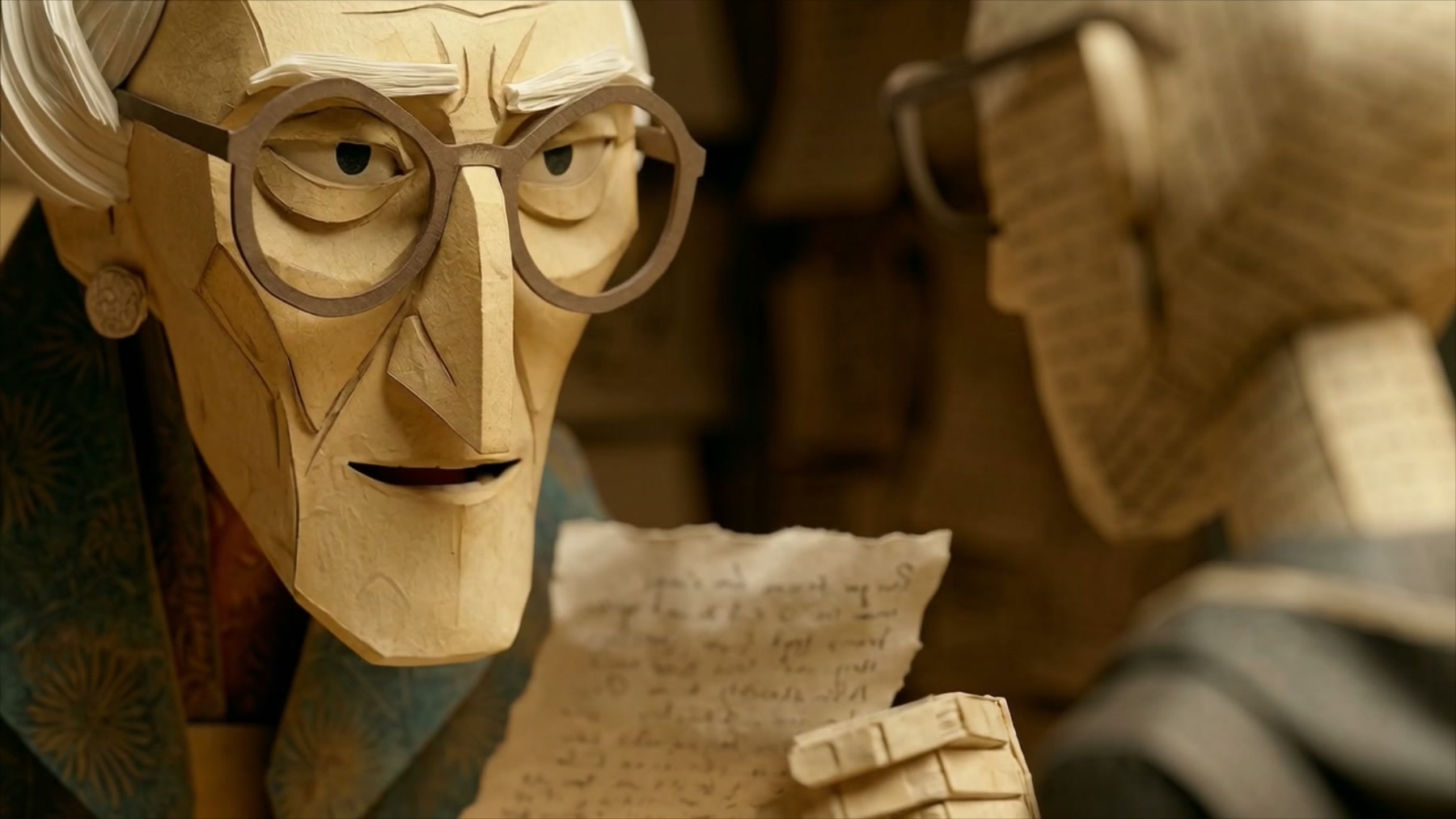 Film still: the archivist in close-up, stern, holding a handwritten document