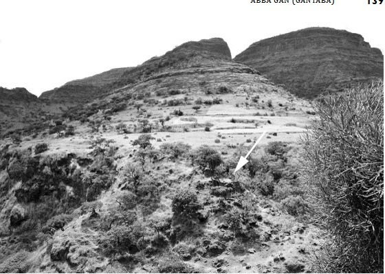 A black-and-white photograph of a mountainside in the Səmen, with a site marked