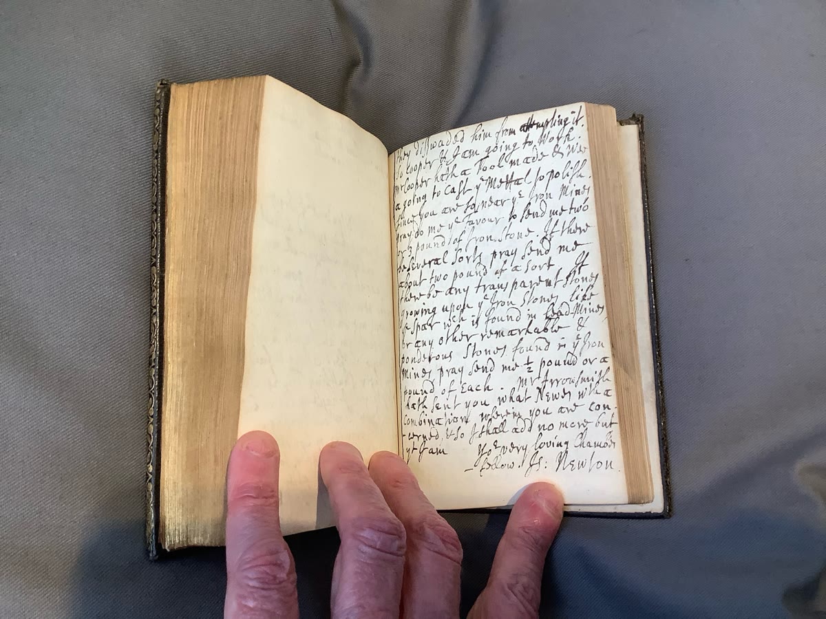 A page of Wickins's notebook, held open in a hand, in seventeenth-century handwriting